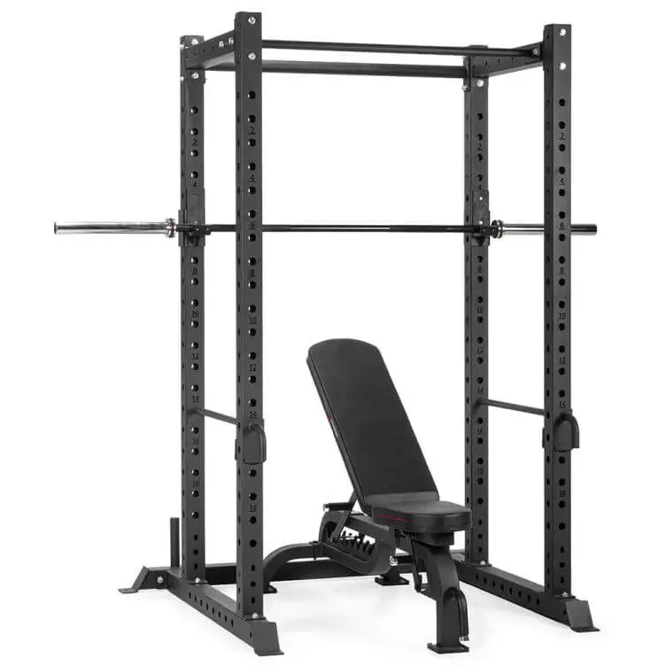 Gymstick Alpha Power Rack Pro Gym -voimahäkki, säädettävä penkki ja levytanko vaaleaa taustaa vasten.